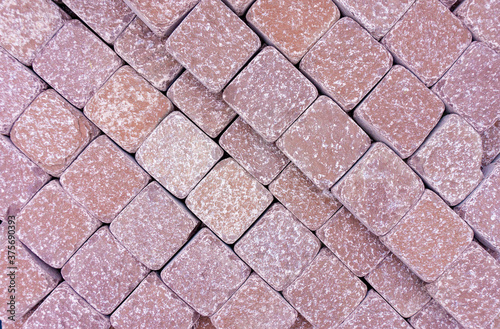 Stone paving stones for garden paths and sidewalks. Background from red squares. Texture of red square stone tiles. Paving paths with baked sandstone paving stones