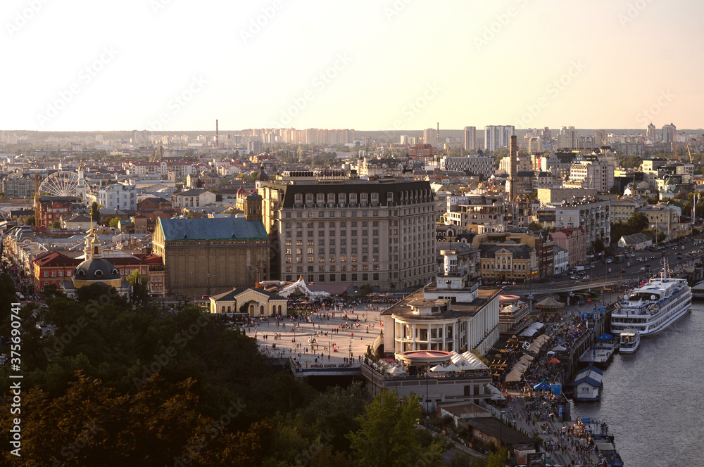 Vintage buildings in Podil neighbourhood near Dnipro river in Kyiv city in the warm summer evening view from the top
