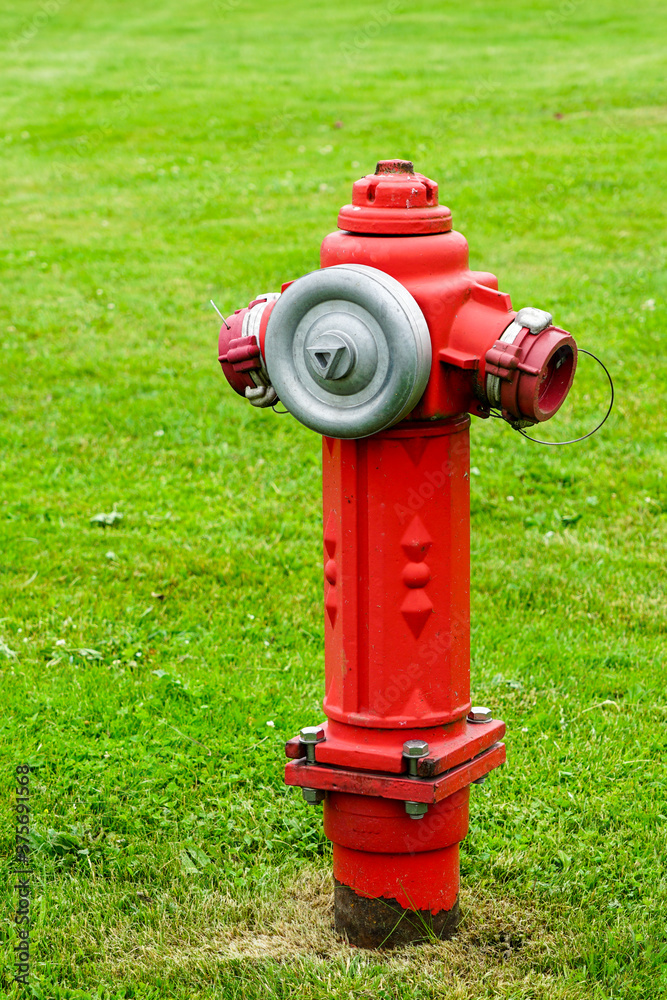 red isolated fire hydrant sits in a freshly cut grass field