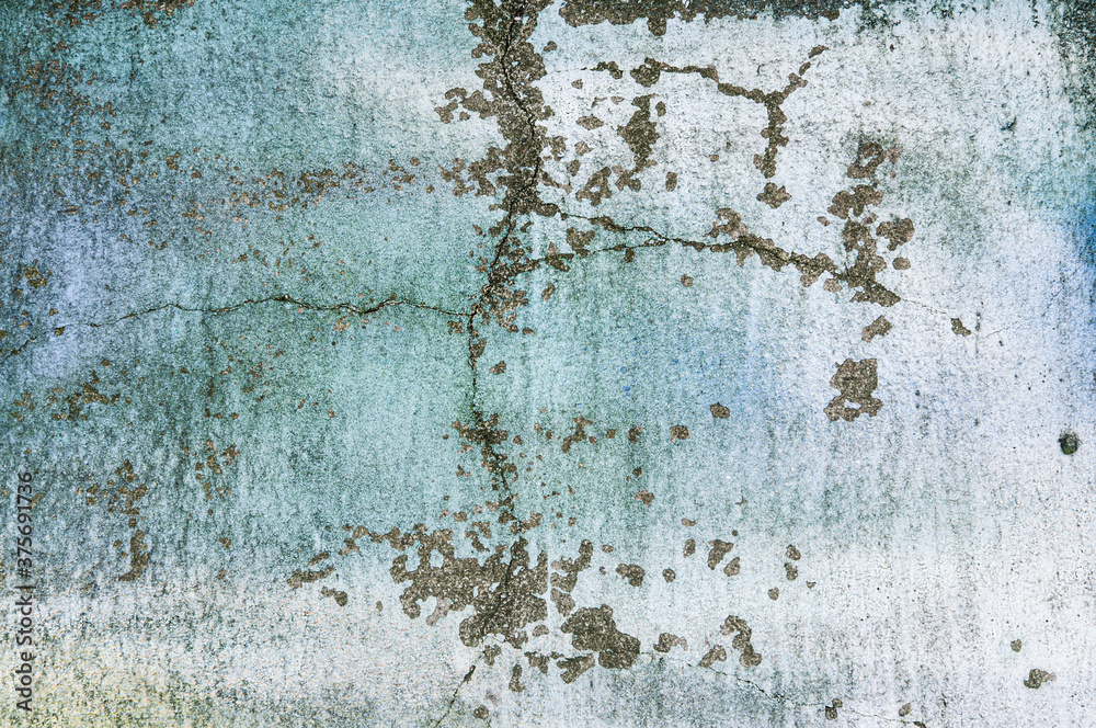 Fototapeta premium Texture of old blue painted building wall with cracks and smudges close up