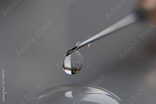 gota de medicina vacuna con aguja jeringa y frascos farmacéutico sobre base blanca  © patoouupato