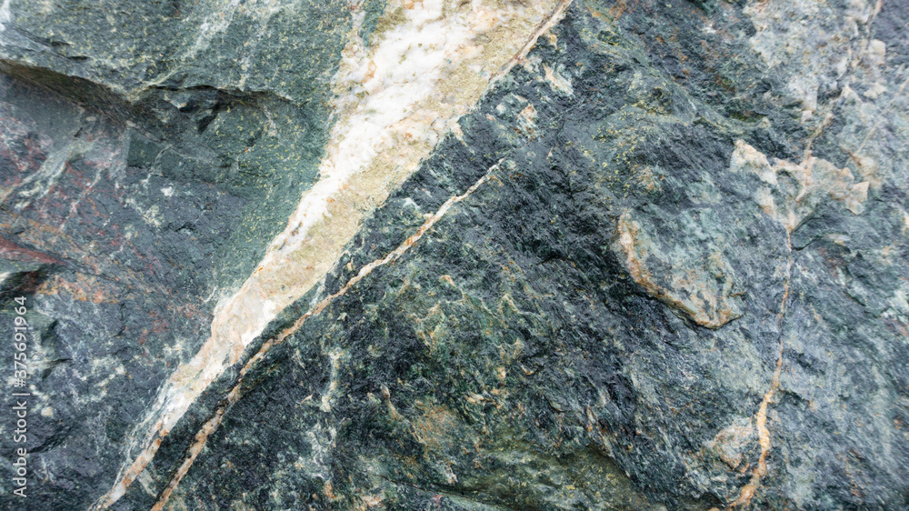 Abstract gray-green background with gabbro diabase stone texture. Stone background of gabbro-diabase boulder. Boulders in landscape design. Abstract gray-green background with gabbro diabase stone texture. Stone background of gabbro-diabase boulder. Boulders in landscape design.