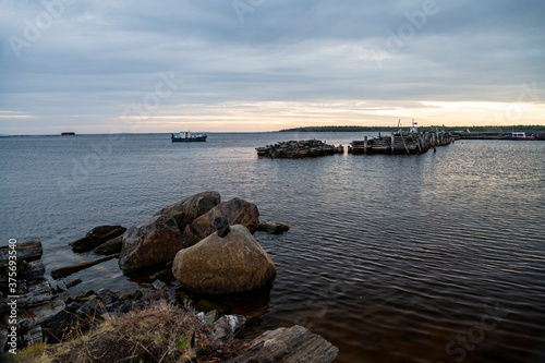 beautiful landscape with old wooden port  stones and sea at sunrise