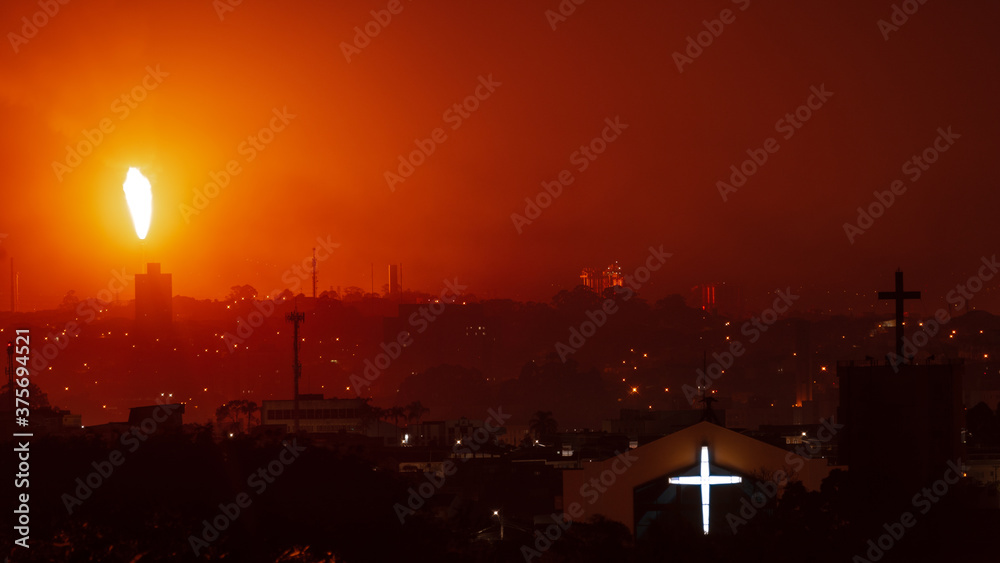 burning petrochemical site and a church