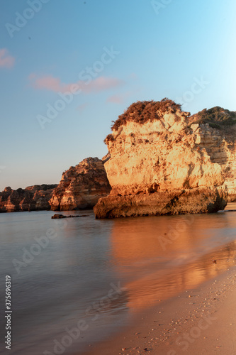 Sunrise on the beach. Early morning, calm ocean. Lagos, Algarve Coast, Portugal