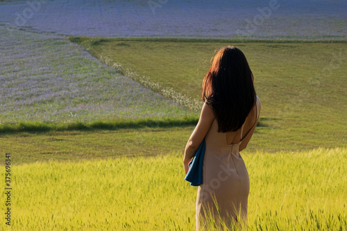 Ragazza mora capelli lunghi mentre guarda la vallata di Castelluccio di Norcia photo