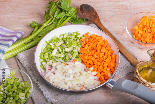 Cooking carrot and celery onion vegetable dressing, chopped ingredients for Mirepoix or Soffritto in a skillet photo