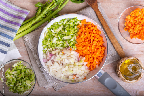 Cooking carrot and celery onion vegetable dressing, chopped ingredients for Mirepoix or Soffritto in a skillet