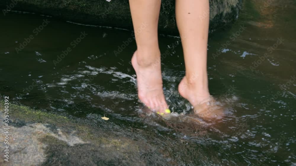 Girl splashing with legs in water Girl splashing with legs in water