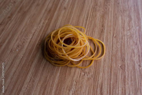 Rubber bands. Rubber bands on the wooden table. Yellow rubber bands. 