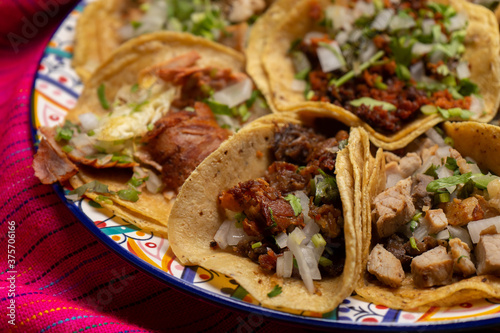 Assortment of mexican tacos on pink background