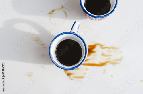 Two coffee cups and coffee stain view from above photo