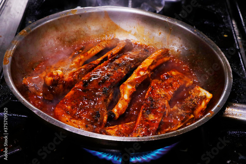 sticky barbecue pork ribs.in pan with hot sauce