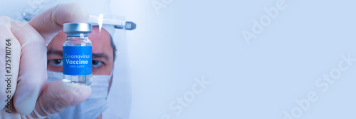 Coronavirus Vaccine - Banner Doctor with surgical glove holding a vaccine vial with the blue label written Coronavirus Vaccine - Sars-Cov-2 over white background