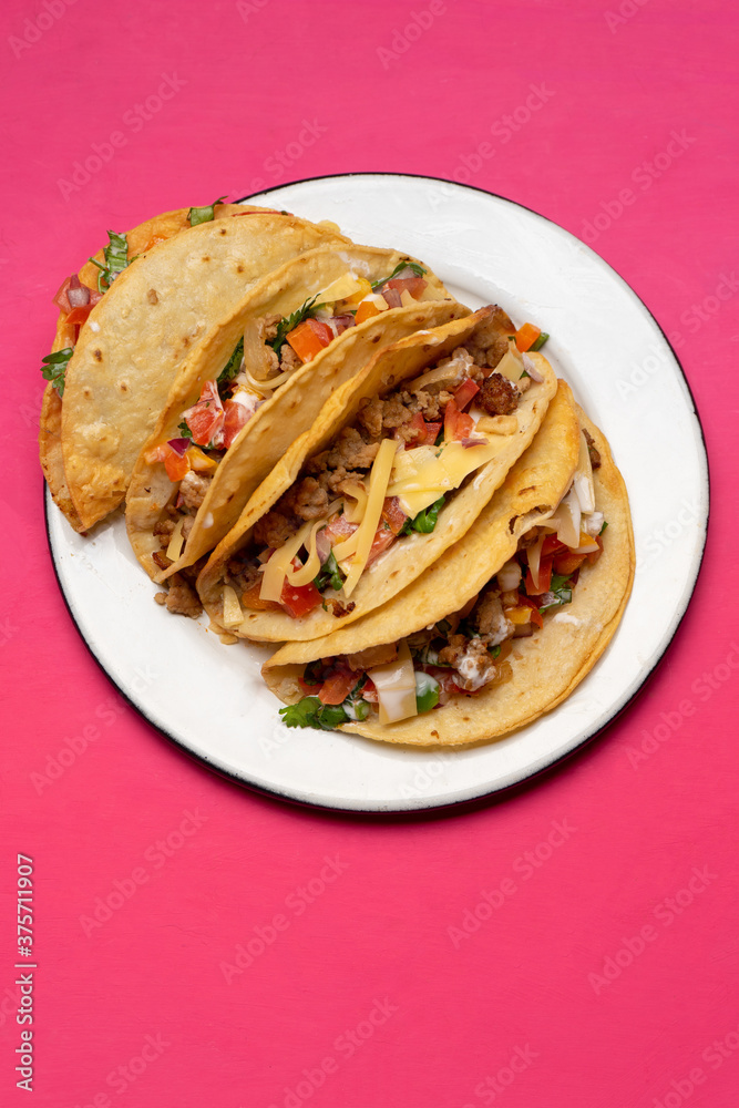 Mexican hard-shell tacos with meat and fresh sauce on pink background Mexican hard-shell tacos with meat and fresh sauce on pink background