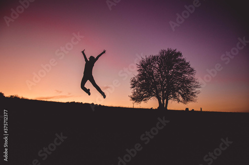 Girl Jumps so high with sunset in the background