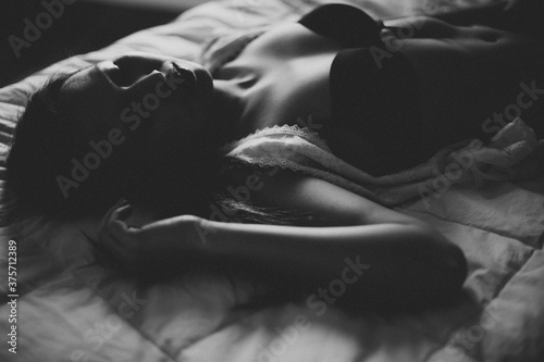 Woman in black bra lying on bed photo