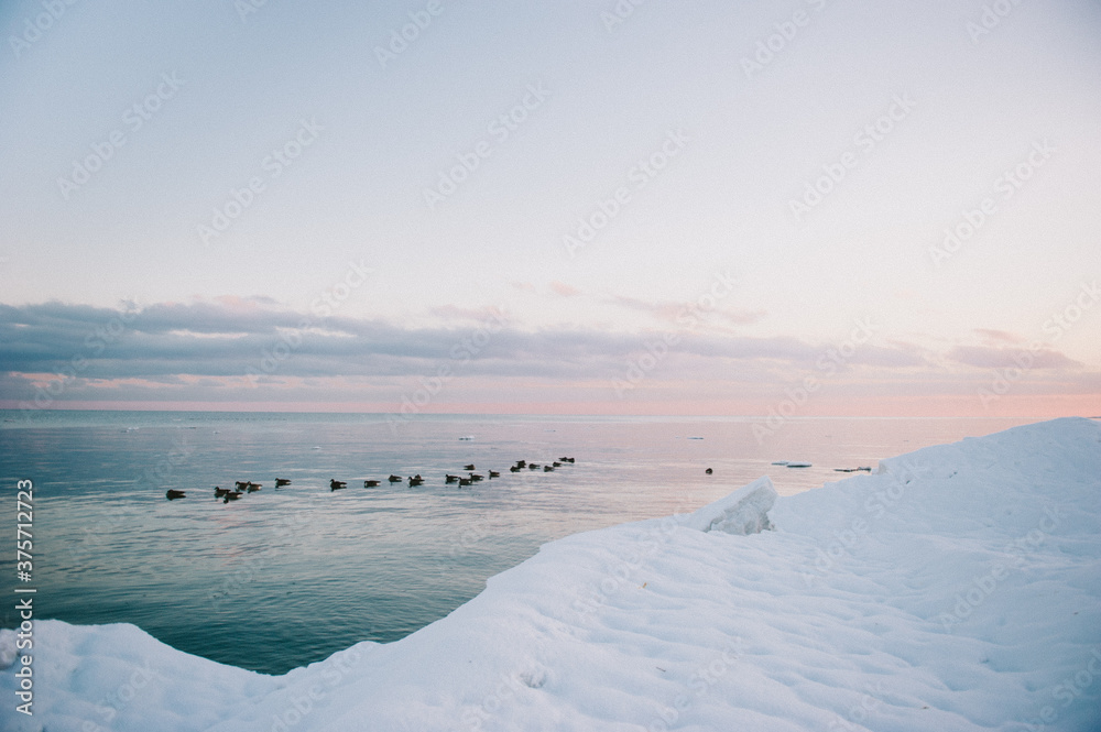 Purple and blue cloudy sky at sunset over frozen winter lake Purple and blue cloudy sky at sunset over frozen winter lake