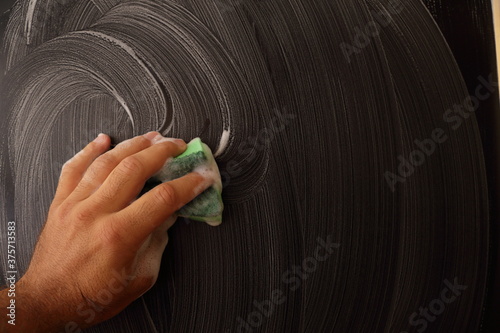 Cleaning black sureface of board with detergent perfect for laundry and house keeping photo