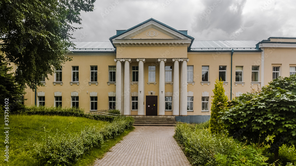 Facade of two-storey house with columns. Old beige mansion of the 18th century. Vintage estate in Russia