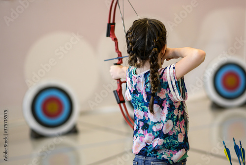 Girl Shooting Bow and Arrow at Target
