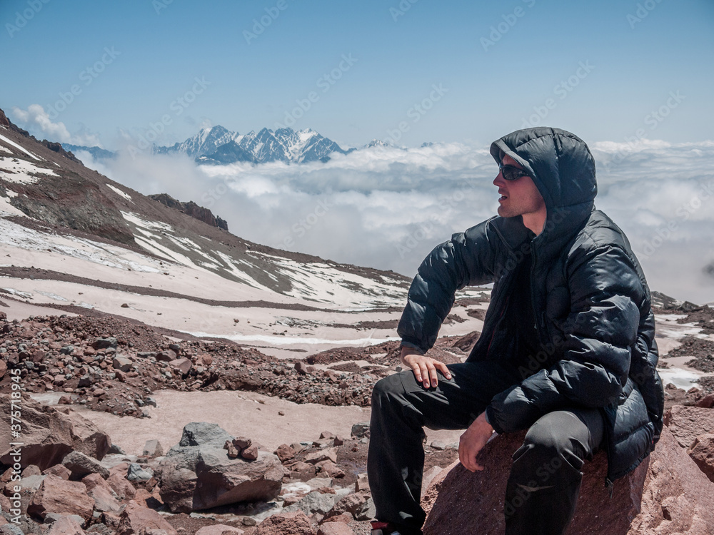 Young hiker sitting on a stone with inversion in the background Young hiker sitting on a stone with inversion in the background