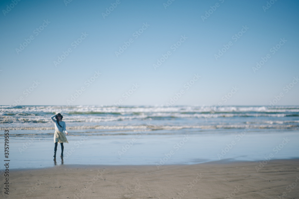 Blurred Young Woman on the Beach with Bright Blue Skies Blurred Young Woman on the Beach with Bright Blue Skies