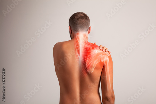 Shoulder scapula pain, man holding a hand on a painful zone	
