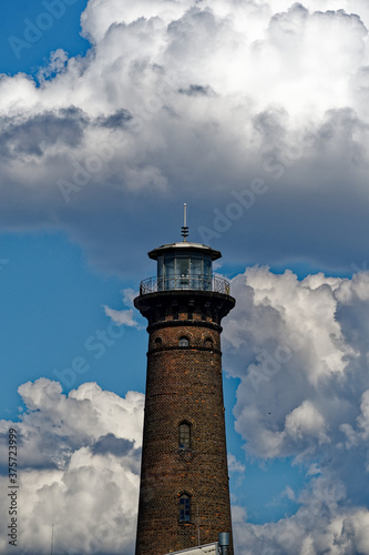 the helios lighthouse in ehrenfeld against a sky with cumulus clouds