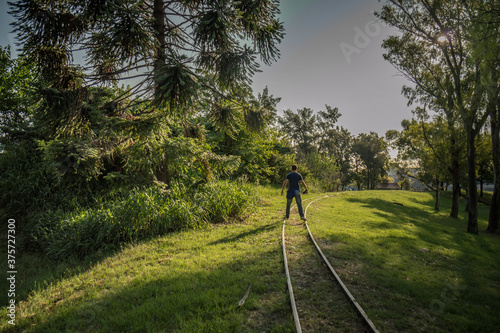 Obraz na płótnie Unrecognizable young man walks on the abandoned train tracks w salonie