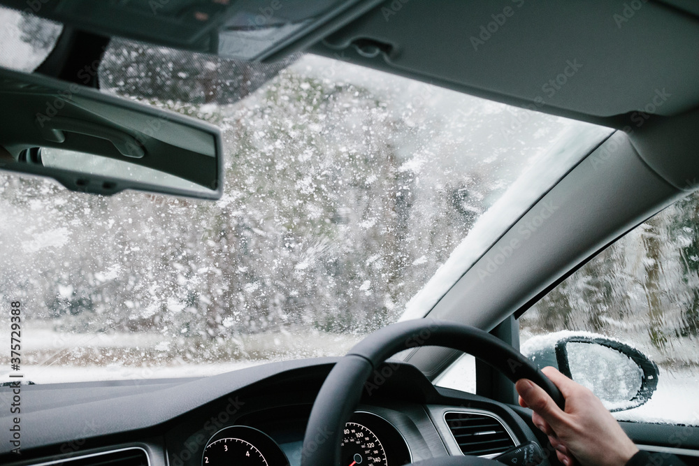View from inside a car driving in the snow. View from inside a car driving in the snow.