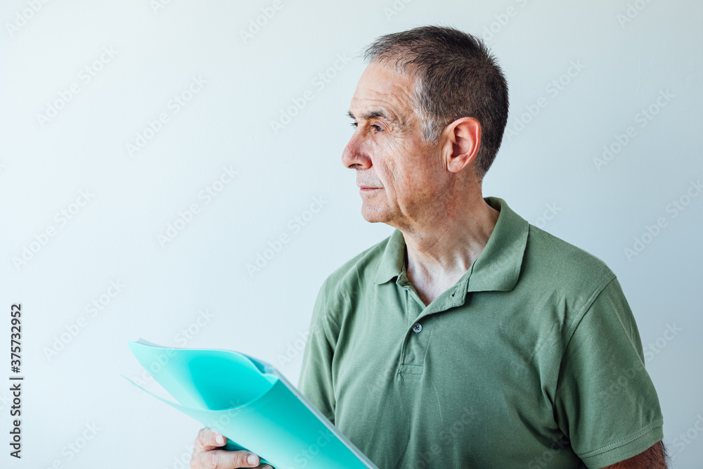 Entrepreneur retired man wearing a green shirt holding a folder with a report