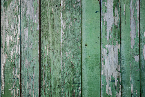 Background, texture, old wooden fence wall, peeling paint around the perimeter.