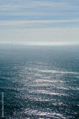 Sunlight reflecting on expansive Pacific Ocean at dusk