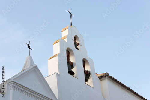 The cross and bell tower of Catholic church in Spain. photo