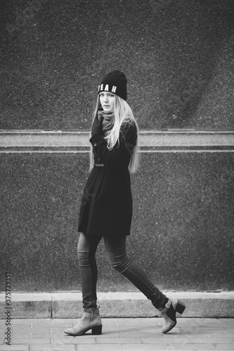 young woman with long blond hair walking on the street photo