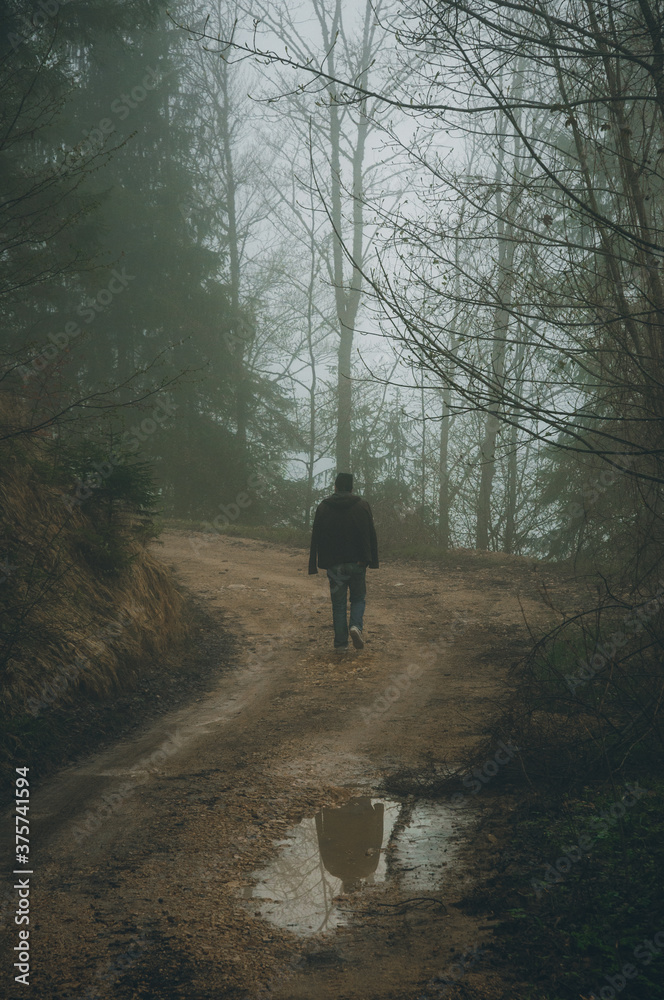 Man walking through the misty forest Man walking through the misty forest