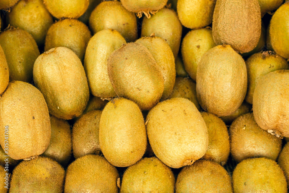 Natural ripe kiwis piled up at market,close up backgrounds Natural ripe kiwis piled up at market,close up backgrounds