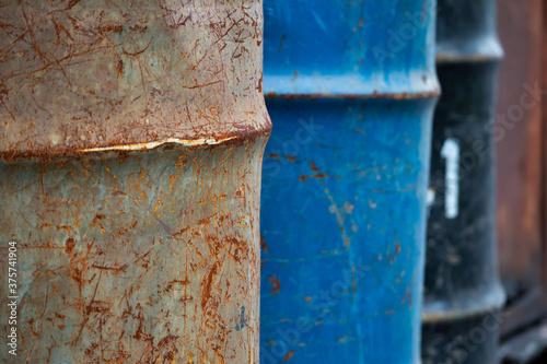 Rusty old metal drum lined up outside the warehouse. photo