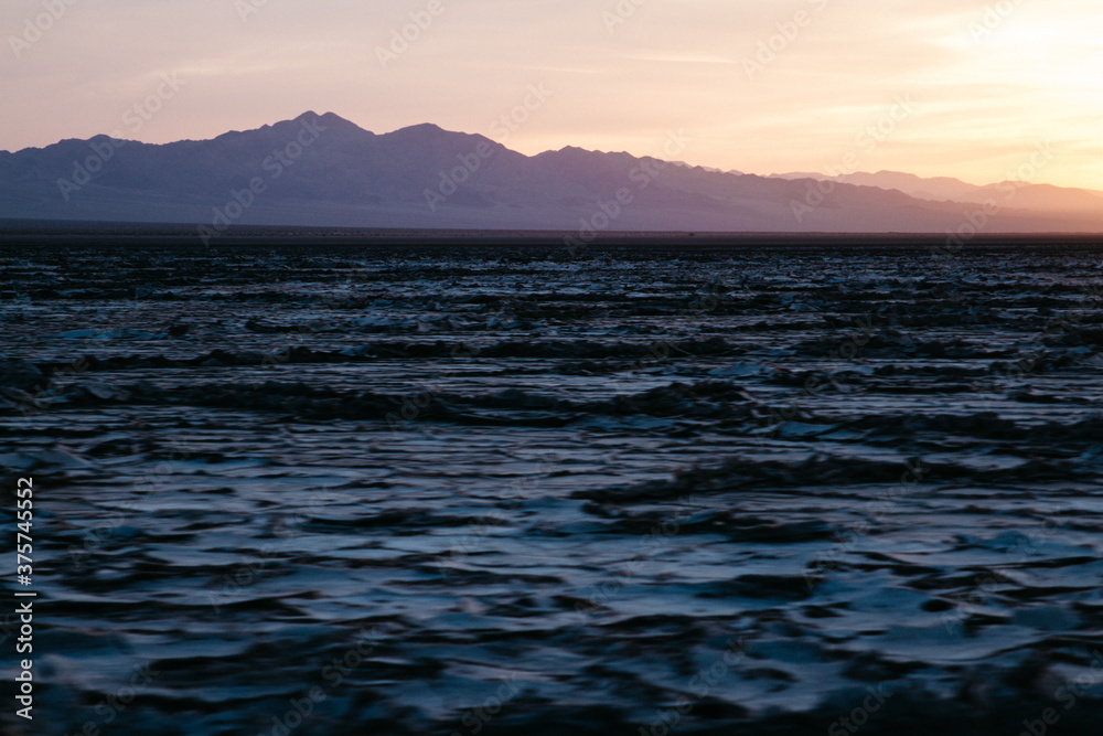 salt beds near mountains at sunset during road trip
