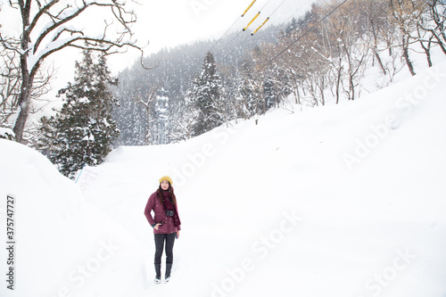 A young asian girl standing in the snow photo