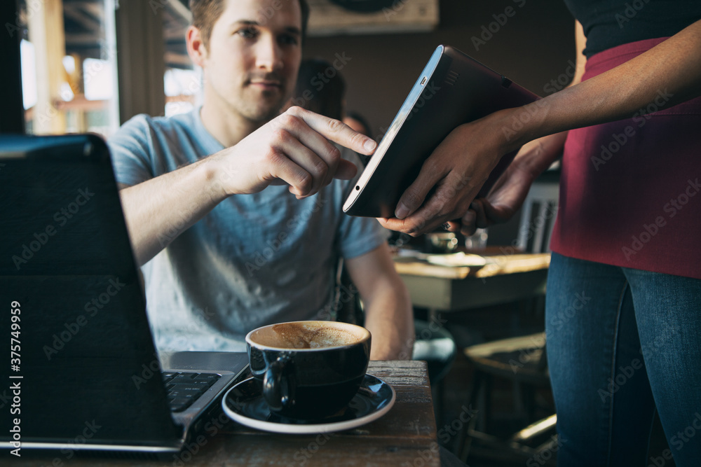 Cafe: Man Uses Digital Tablet To Sign For Restaurant Bill Cafe: Man Uses Digital Tablet To Sign For Restaurant Bill
