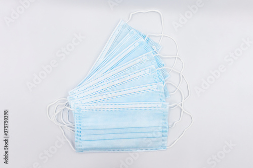 Blue medical face masks prevent dust and coronavirus  COVID-19  many pieces isolated on white.