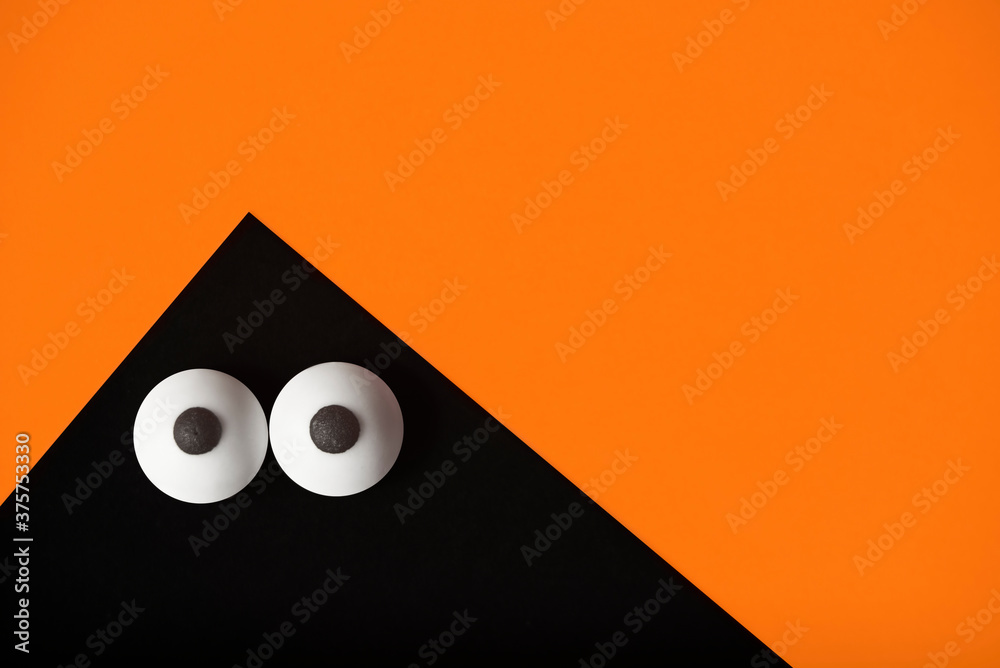 Φωτογραφία Halloween background, black ghost with bulging eyes on a orange