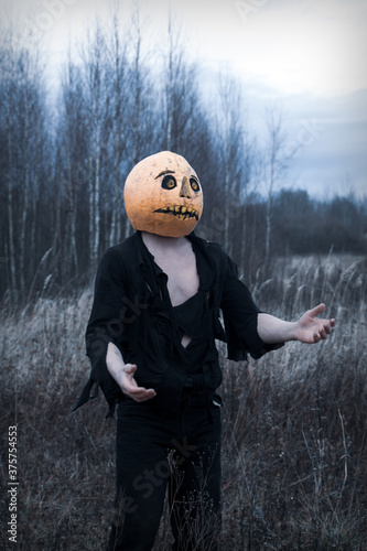 Lost in the woods a guy in a pumpkin with a lantern  wanders in search of a means of getting rid of the autumn depression