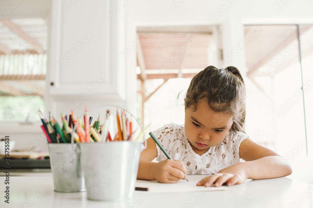Young homeschool girl doing writing lesson in kitchen Young homeschool girl doing writing lesson in kitchen