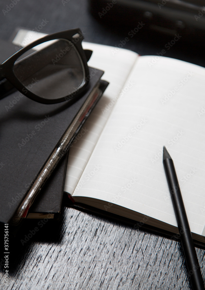 blank paper and pen on a black working desk
