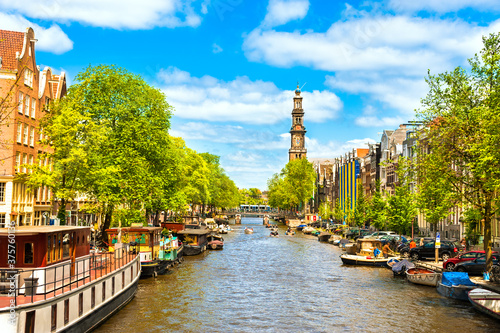 Crowded Amsterdam canal houseboats Westerkerk Church cathedral under brilliant sunny summer sky photo