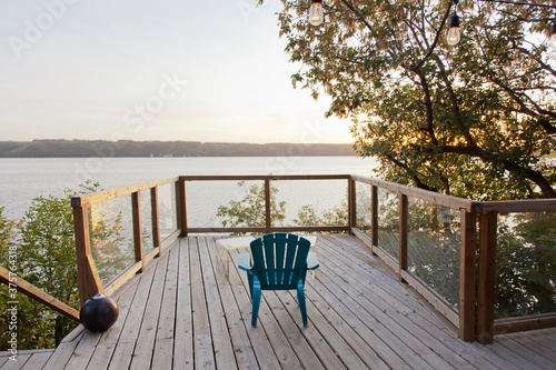 Lakefront patio with a single blue chair