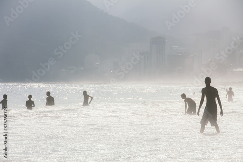 Silhouette of people on the beach. Ipanema beach in rio de Janeiro, Brazil photo